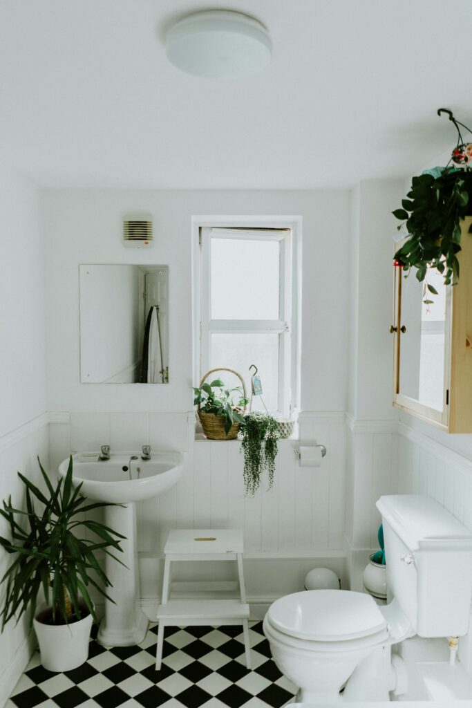 Bright white bathroom with basin, toilet and chequered floor after installation